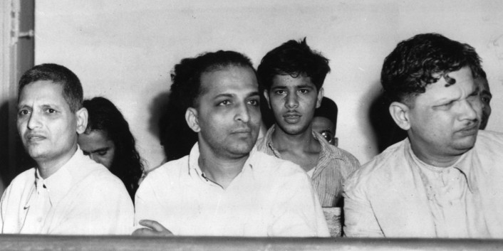 The men accused of the assassination of Mahatma Gandhi listen to testimony in a courtroom during their arraignment in New Delhi, India, on May 27, 1948.  Gandhi was shot three times by Nathuram Vinayak Godse, center, on his way to a prayer meeting from Birla House on Jan. 30.  At left is Narayan Dattraya Apte and at right is Vishnu Ramkrishna Karkare.  In second row at center is Madan Lal, accused of exploding a bomb on Jan. 20 outside a Gandhi prayer meeting at Birla House.  (AP Photo)